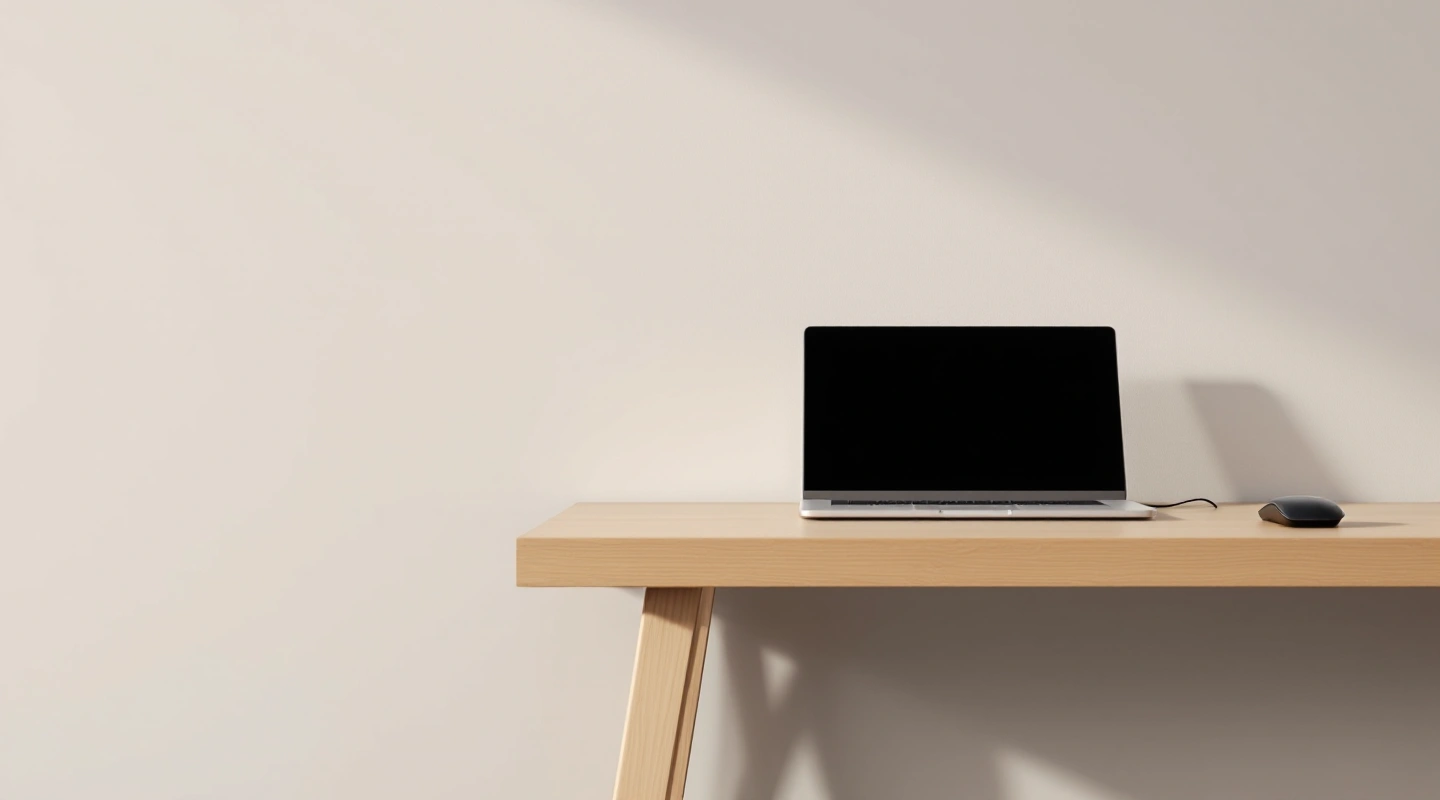 A plain laptop and wired mouse on a light wood desk